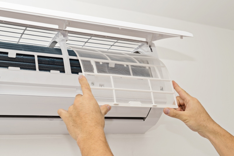 Changing the filter of a ductless air conditioner.